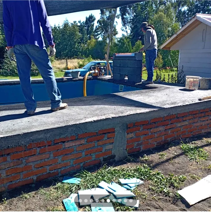 Equipo realizando trabajos de terminación junto a una piscina